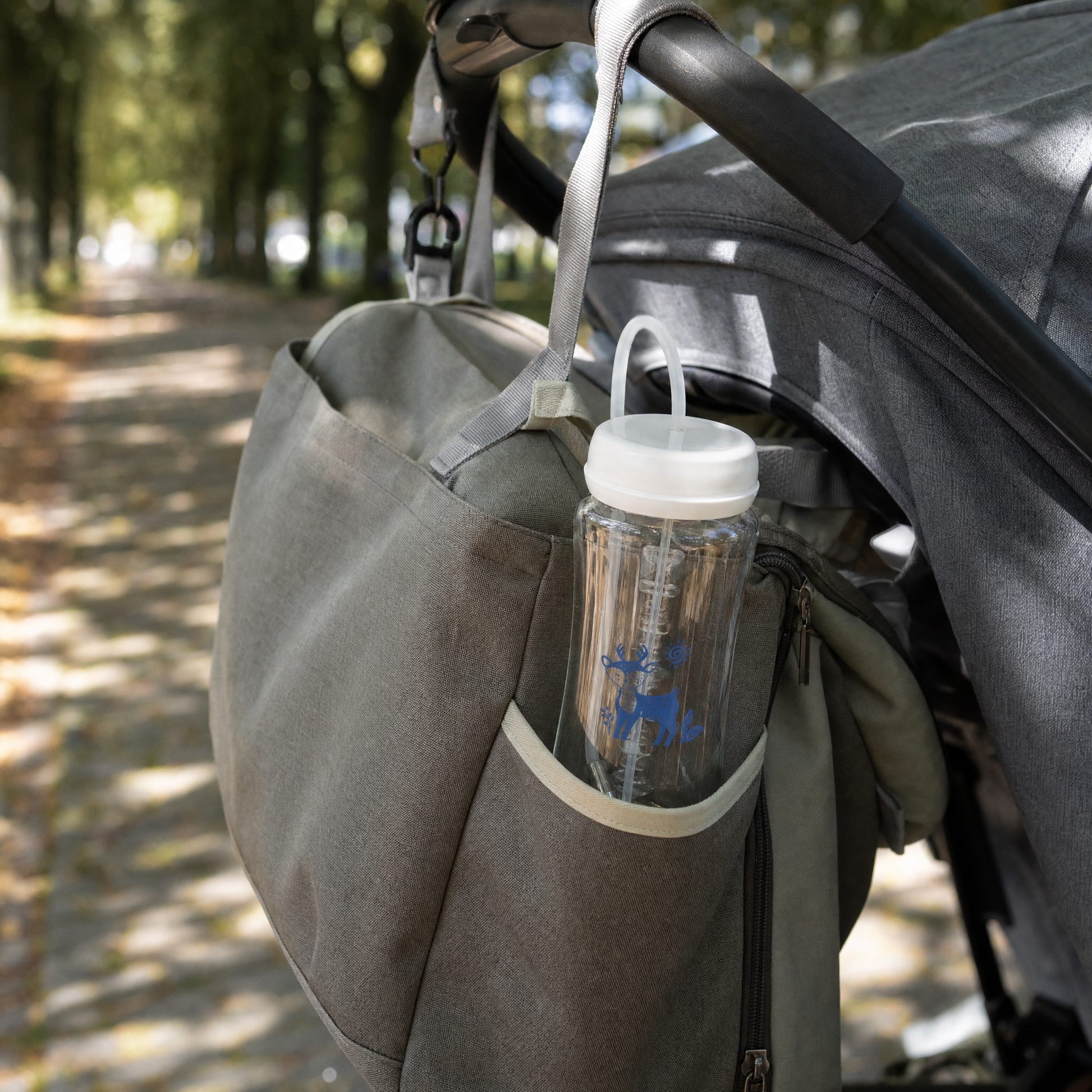 EasySip bottle tucked into a changing bag hanging from a pram handle