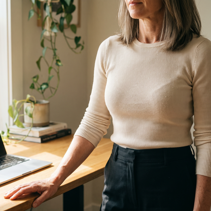 Standing tall in a fitted cream knit top with a smooth line across the shoulders