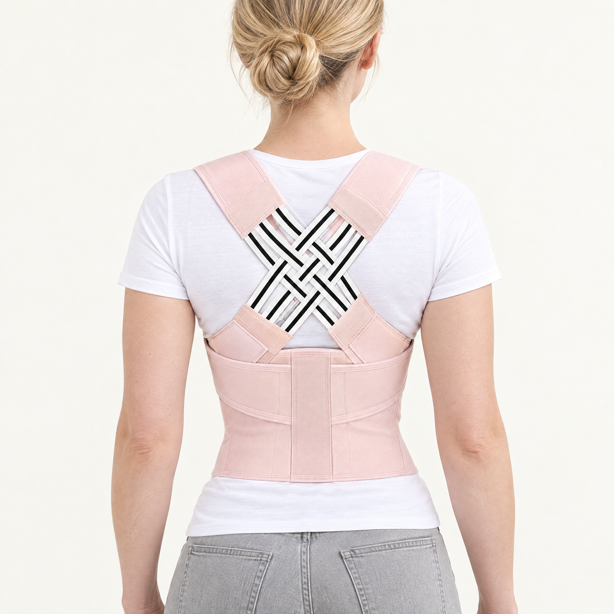 Back view of the PostureOn brace in blush pink worn over a white t-shirt, woven crossed panel across the upper back