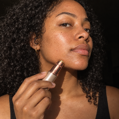 Woman gliding the PeachPen face shaver along her jawline
