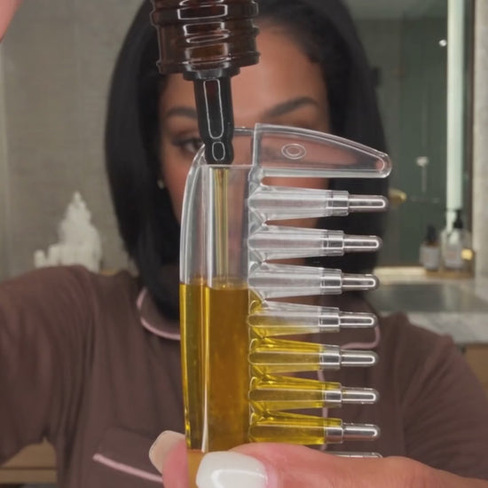 RootDrop hair oil applicator comb being filled with oil and drawn along a hair parting
